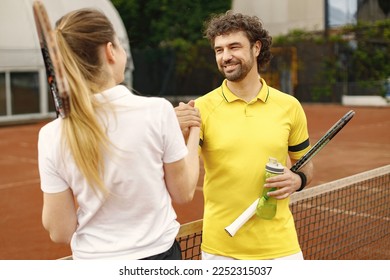 Two tennis players shaking hands at tennis court before the match - Powered by Shutterstock