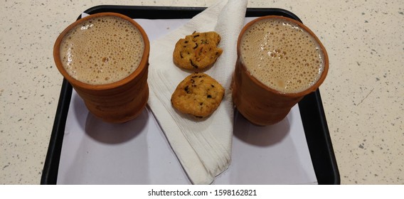 Two Terracotta Tea or coffee cups made of mud or sand called kulhad/kullhad used to serve authentic indian drinks with salted cookies. Top view