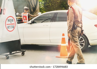 Two Thai policemen divide their duties into outdoor traffic on crowded roads by car, driving with caution in the evening at the checkpoint : (Thai ) Pay hyud trwc 
English language Stop sign (Check)

