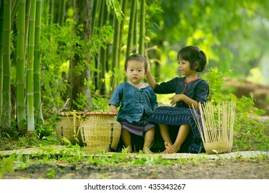 Two Thai Tribe Child Are Playing At Bamboo Forest Northeastern Of Thailand.