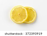 two thin slices of fresh lemon on white background