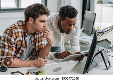 two thoughtful multicultural programmers working at workplace together - Powered by Shutterstock