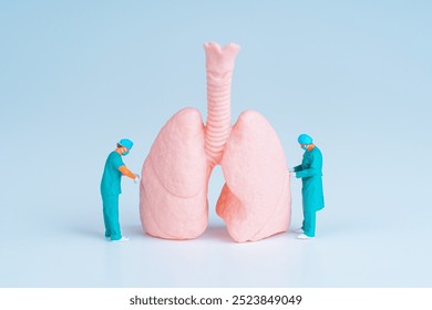 Two tiny surgeons examining a large pink lung model, symbolizing medical practices and healthcare advancements.