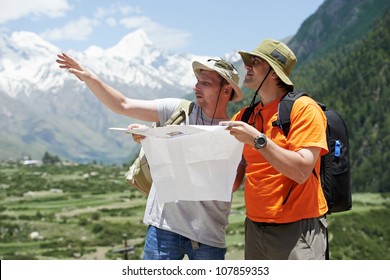 two tjourist trvellers discussing route with map in Himalayas mountains - Powered by Shutterstock
