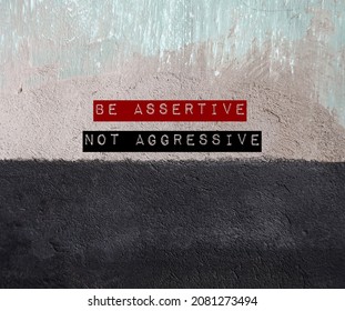 Two tone grunge wall with text written BE ASSERTIVE NOT AGGRESSIVE - concept of standing up for oneself but not violate another. Be direct, honest, express opinion without humiliate or put down anyone - Shutterstock ID 2081273494