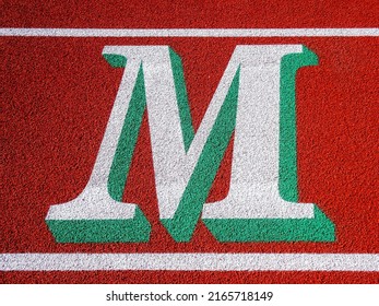 Two Tone M Painted On Running Track.	