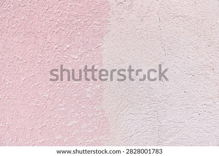 Two tone stucco wall texture with vertical split of pink and beige, rough cement surface with crack