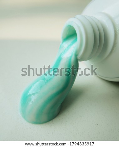 Two toned herbal toothpaste oozing out of tube