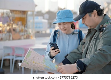 Two Tourists Checking Navigation and Paper Map Outdoors