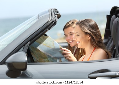 Two tourists reading a map searching destination in a convertible car on summer vacation - Powered by Shutterstock