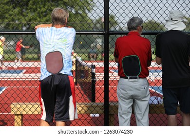 Two Tournament Players Watch As They Wait To Play In Their Pickleball Match