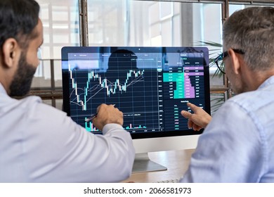 Two traders brokers stock exchange market investors discussing crypto trading charts growth using pc computer pointing at screen analyzing financial risks, investment profit forecast. Over shoulder - Shutterstock ID 2066581973