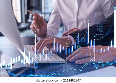 Two traders man and woman researching historic data to predict stock market behavior using laptop. Internet trading concept. Forex and financial hologram chart. Forecasting and planning. - Shutterstock ID 2111482247