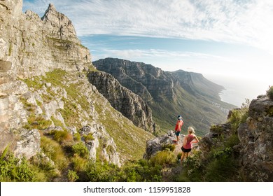 Two trail runners enjoying the view of Table mountain and the mountains of the  Cape Peninsula at sunset