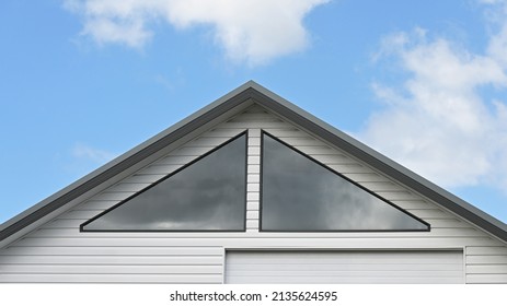 Two triangle shaped windows in a gable roof