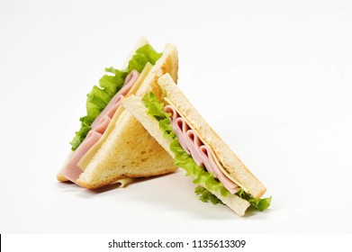Two triangular sandwiches with cheese and ham. The sandwich is made from slices of fried white bread. Close-up. White background.
