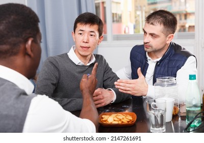 Two Troubled Men Having Serious Talk With Their Friend At Home