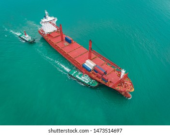 Two Tug Boat Drag Container Ship In Shipping Port Area, Thailand.