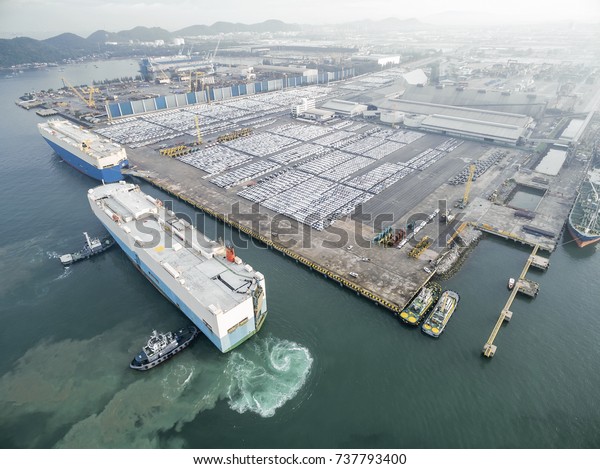 two tug\
boat towing car carrier ship go to dock\
.