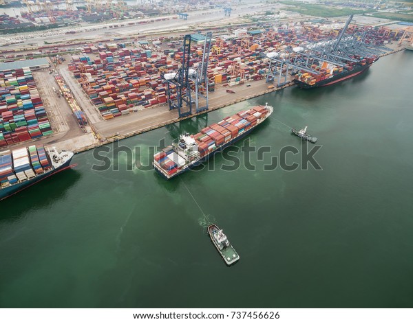 two tug boat towing cargo container in warehouse harbor\
at thailand .