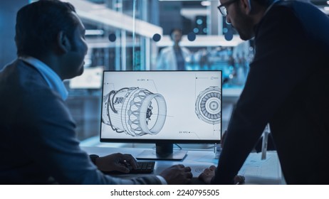 Two Turbine Engine Developers Working on Programming a Prototype Jet Engine on Desktop Computer. Young Team of International Industrial Science Specialists Developing a Turbine Motor in the Background