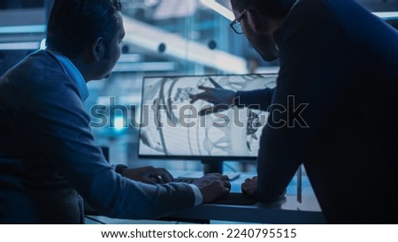 Two Turbine Engine Developers Working on Programming a Prototype Jet Engine on Desktop Computer. Young Team of International Industrial Science Specialists Developing a Turbine Motor in the Background