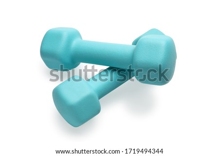 Two turquoise colored rubber dumbbells lying at white table close-up