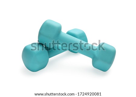 Two turquoise colored rubber dumbbells lying at white table close-up