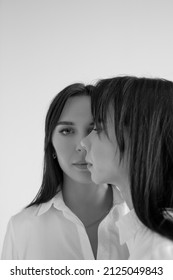 Two Twin Sisters In White Shirts And Blue Jeans