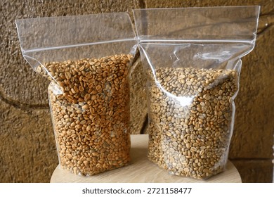 Two types of grains packed in transparent plastic bags displayed on a wooden surface, representing food packaging and small business products