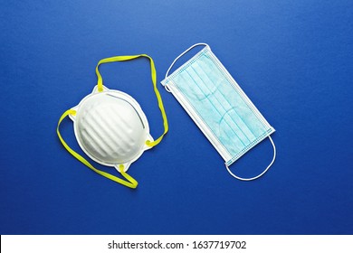 Two types of protective face masks on blue background. Protective masks as precaution in spread of coronavirus 2019-nCoV, Wuhan virus, flat lay - Shutterstock ID 1637719702