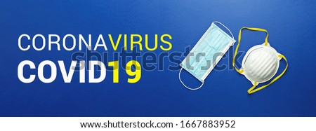 Two types of protective face masks on blue background with inscription CORONAVIRUS COVID-19. Protective masks as precaution in spread of coronavirus Covid-19 around world, banner, flat lay