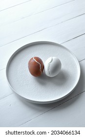 Two Ugly Boiled Cracked Eggs On A White Plate.