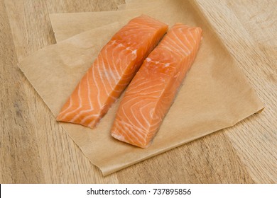 Two Uncooked Salmon Fillets On Greaseproof Paper