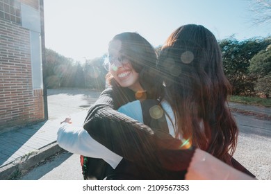 Two University Student Friends Embracing Each Other Happy After Meeting Again At Campus After Holiday. Hug Lovely Concept. Study And Learn Together Concept. Back To School And Class.