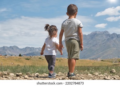 Two Unrecognizable Toddlers Walking Backwards In Nature