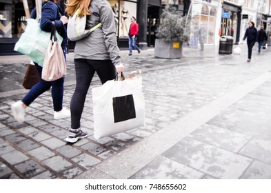 Two Unregognisable People Women Walking Down High End Shopping Street With Shopping Bags