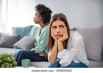 Two upset friends not talking to each other after fight on the sofa in sitting room at home. Two women friend sulking at each other, bad relationship concept.  Friendship, quarrel, female disagreement - Powered by Shutterstock