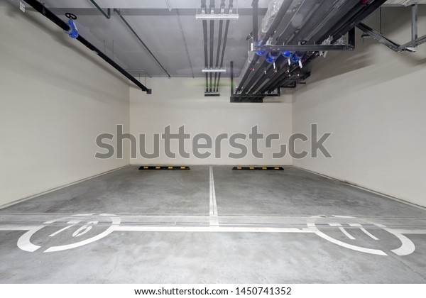 Two vacant parking spaces for cars in the\
underground car parking