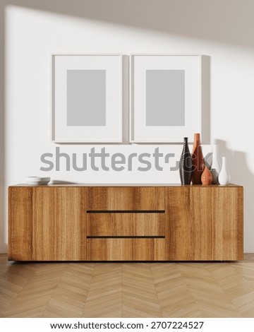 Two vertical white picture frames with matting on a light wall above a cabinet, presented as a mockup for artwork or poster display. 3D render.