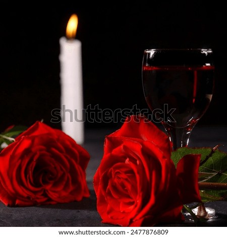 Two vibrant red roses in full bloom, one filled wine glass, a lit candle against a dark background, creating an intimate and romantic atmosphere that can represent love, loneliness, single, heartbreak