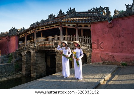 Two Vietnamese woman stand front of japanese bridge