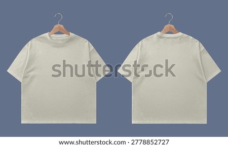 Two views of a light-colored, loose-fitting t-shirt displayed on wooden hangers against a solid blue background. The front and back of the garment are shown.