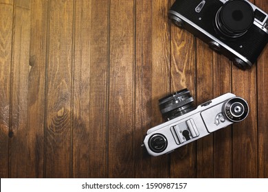 two vintage cameras on wooden boards background