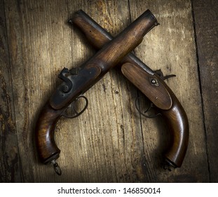 Two vintage pistols on wooden background