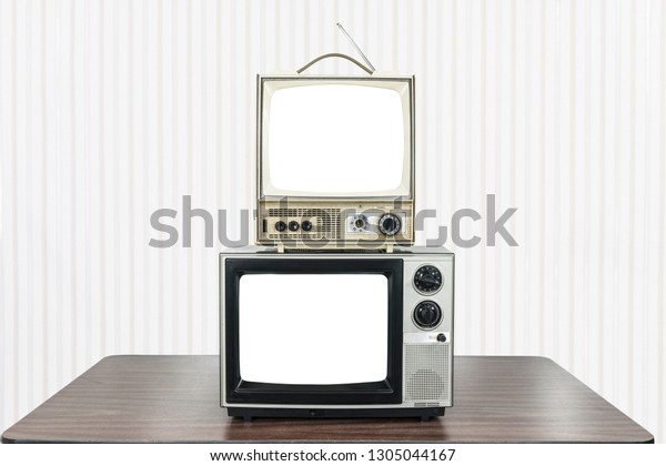 Two vintage television on old table with cut out\
screens. 