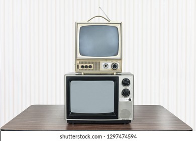 Two Vintage Television Stacked On Old Table.