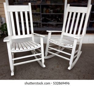 Two Vintage White Rocking Chairs On Front Porch.