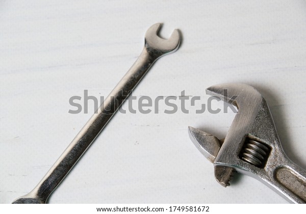 Two vintage wrenches, adjustable\
spanners and spanners, on a light wooden\
background