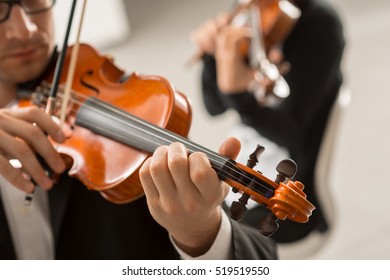 Two violinists performing together hands close up, classical music concert